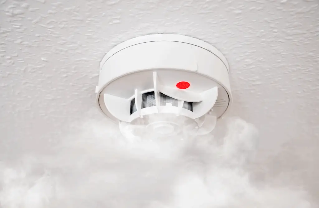 Rauchmelder an der Decke mit aufsteigendem Rauch