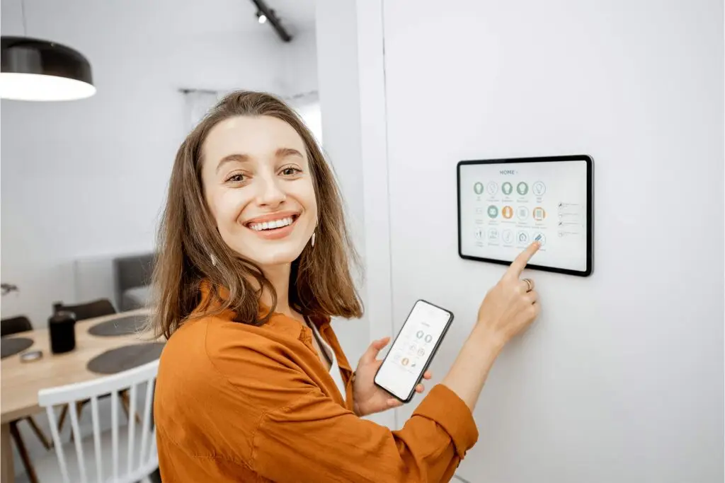 Frau bedient Smart-Home-Steuerung am Wandpanel
